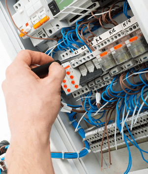 Sähköliikkeen työntekijä huoltaa kiinteistön sähköohjauksia